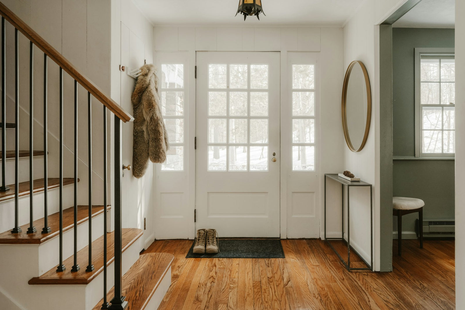 Cozy home entryway with wooden stairs and a glass front door