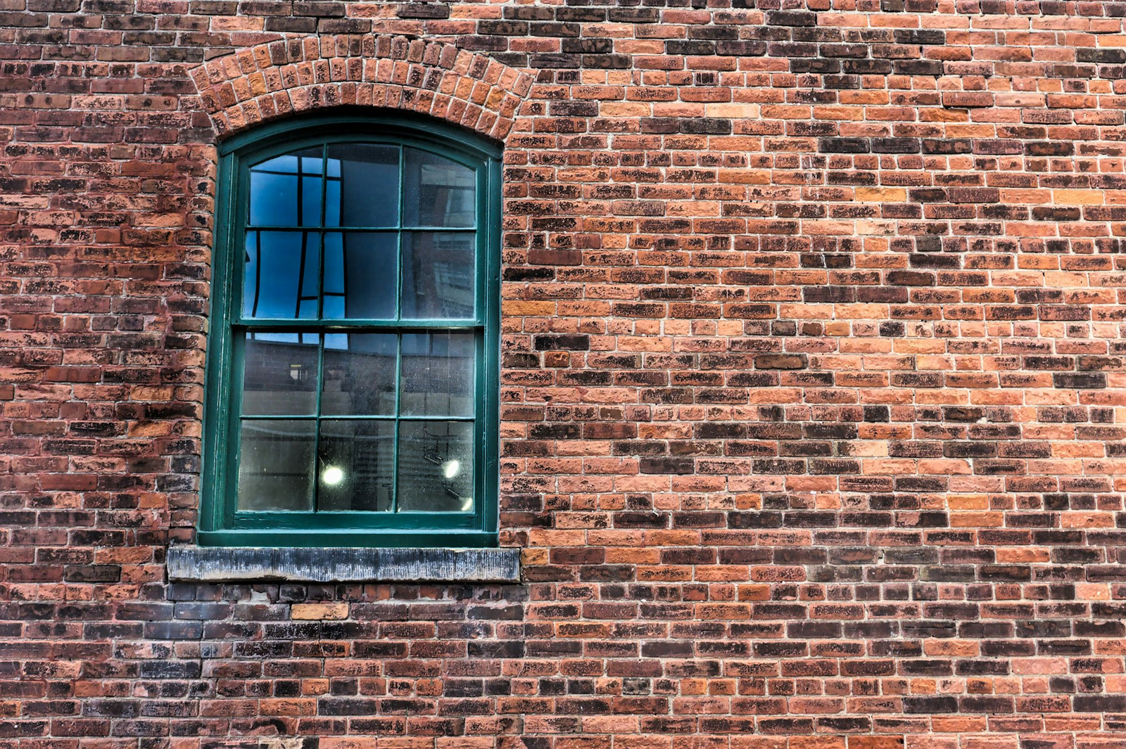 Small blue-framed window set in a brick wall