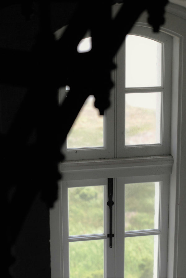 A white wooden framed glass window seen from inside a room
