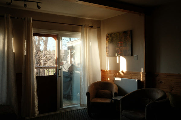Sunlight coming through sliding glass doors onto chairs in a living room