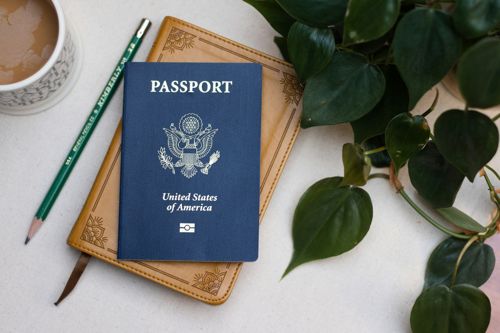 US passport on a table beside a cup of coffee