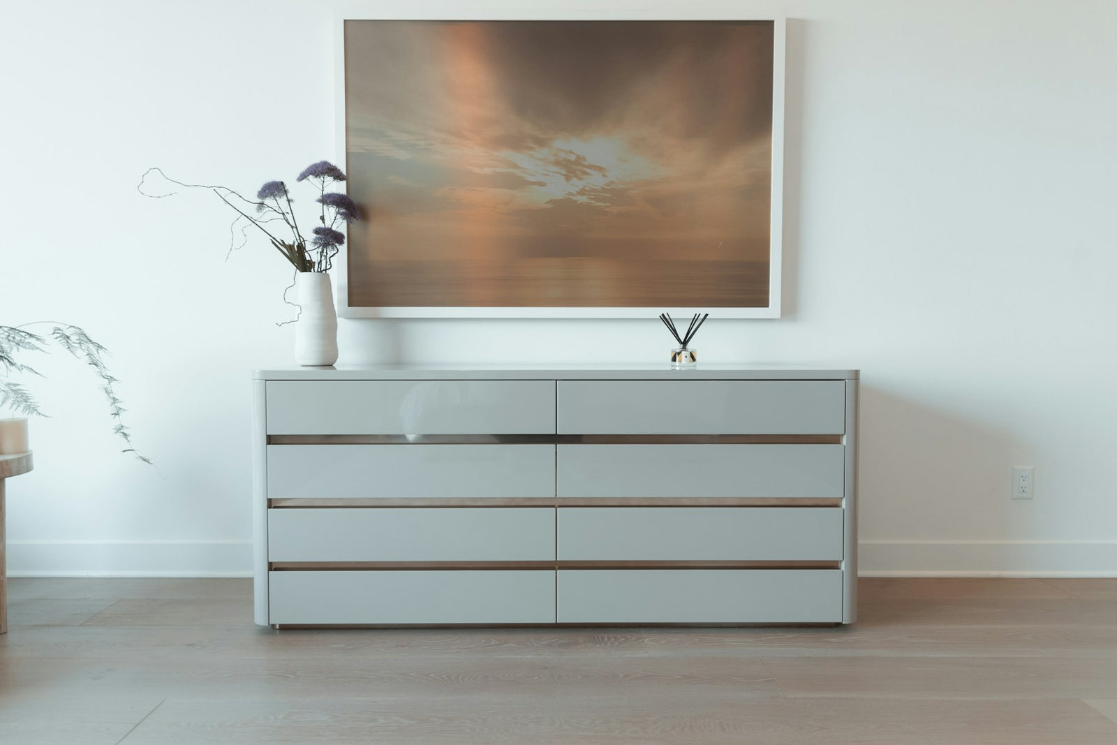 Framed picture hanging above a bedroom dresser