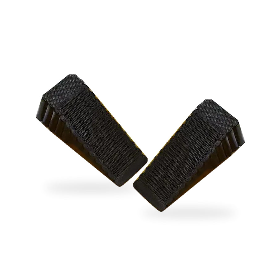 Two black ribbed rubber door stopper wedges on a white background
