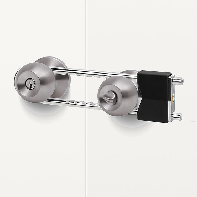 French door security bar clamped across two round door knobs on a white double door, the locking body beside the right knob