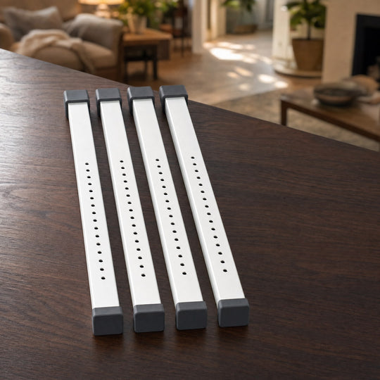 Four white adjustable TremShield sliding window security bars laid in a row