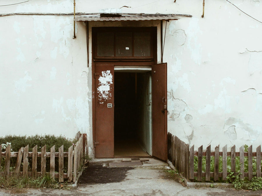 An open brown back door leading into a dark hallway