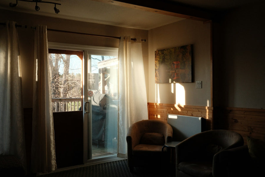 Sunlight coming through sliding glass doors onto chairs in a living room
