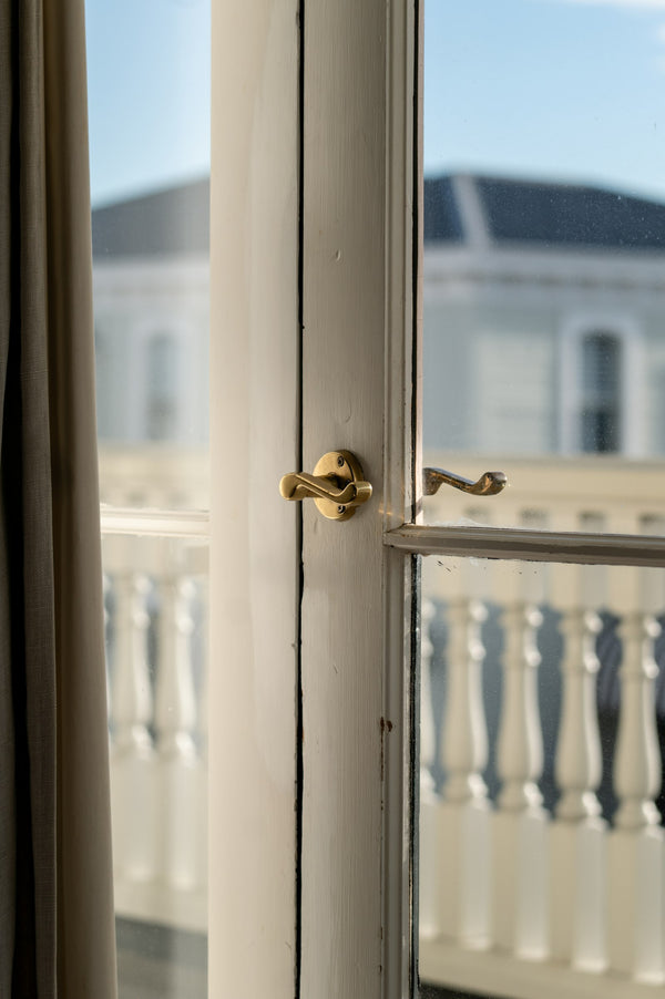 A view through a white door frame out to an apartment balcony