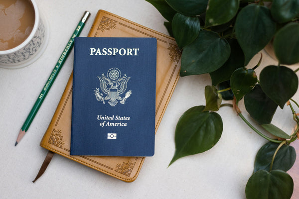 US passport on a table beside a cup of coffee
