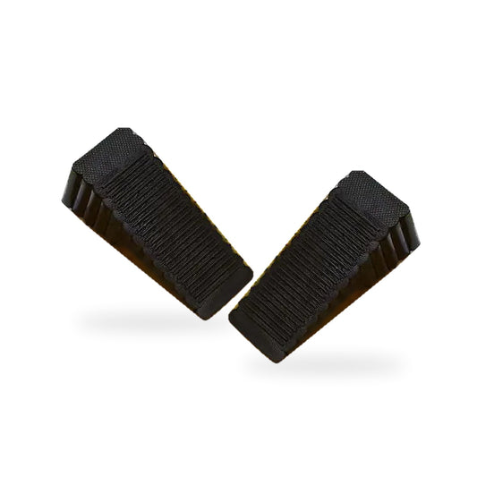 Two black ribbed rubber door stopper wedges on a white background