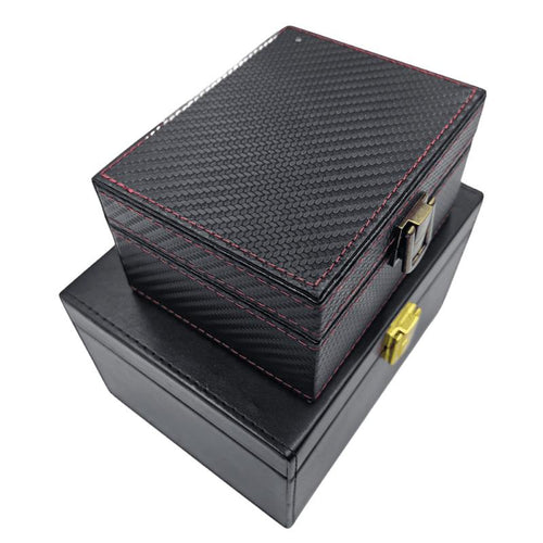 Two black Faraday key boxes stacked: a carbon-fiber textured box with red stitching on a larger leather-look box