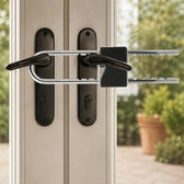 French door security bar fitted across two black lever handles on a pair of French doors, the locking body by the outer lever